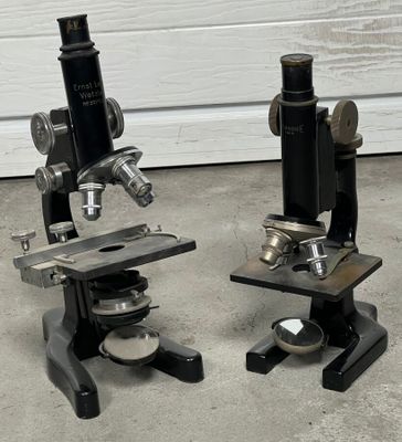 deux microscopes posés côte à côte par terre