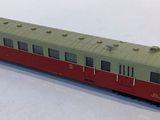 a red and green train on the tracks on a white surface