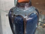 un vase bleu exposé dans une vitrine