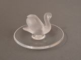 a clear glass swan on a clear plate on a table