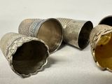 three silver cups sitting next to each other on a table