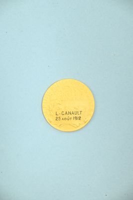 an image of a gold coin on a blue surface with the word l canaut on it