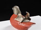 a red bird sitting on top of a piece of paper