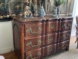a dresser with a vase on top of it in a living room