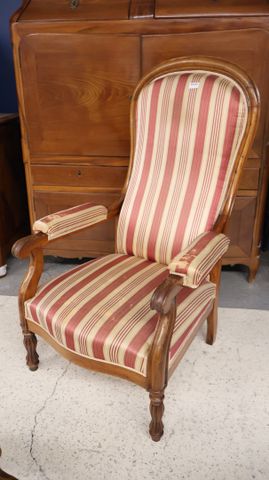 Fauteuil Voltaire garnie de tissu rayé. État d’usage