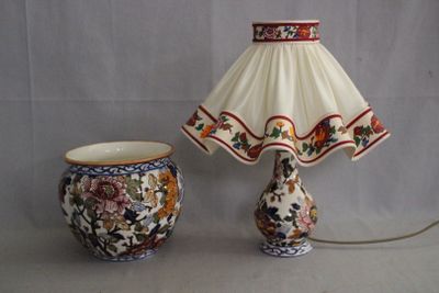 une lampe posée à côté d'un vase sur une table