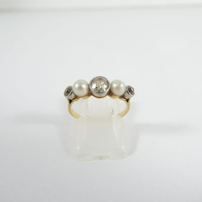 gros plan d'une bague en or avec des perles et des diamants