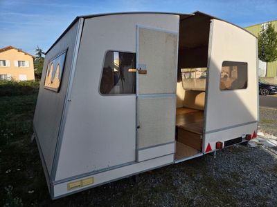 a small white trailer parked on the side of the road