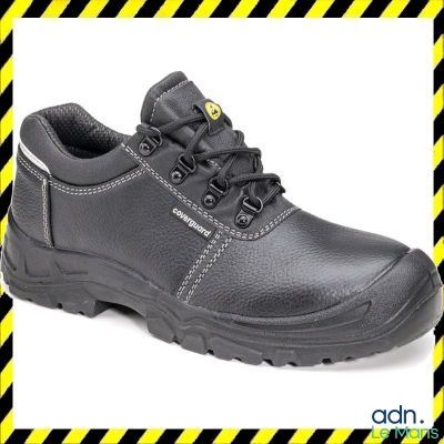 un gros plan sur une paire de chaussures de travail noires sur un fond rayé jaune et noir