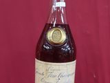 une photo d'une bouteille d'alcool posée sur une surface rouge