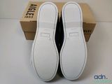 the pair of white shoes are sitting on top of a box