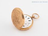 a gold pocket watch sitting on a white surface