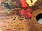 a painting of cherries on a wooden palette