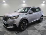 un SUV argenté garé sur un sol en damier dans un garage