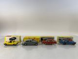 four toy cars are lined up in a row on a white surface