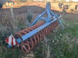 an image of a plow in a field with cows in the background