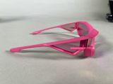 pair of pink sunglasses sitting on a white surface next to a pair of black glasses