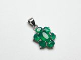 un gros plan d'un pendentif vert posé sur une surface blanche