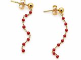 une paire de boucles d'oreilles rouges ornées de perles sur fond blanc