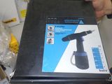 someone is holding a box with a black electric driller inside of it