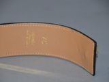 the back of a black leather belt with a gold buckle on it