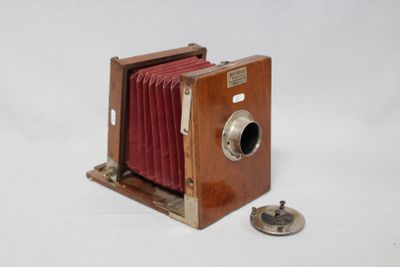 un petit appareil photo en bois avec un cache rouge