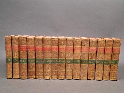 six vieux livres sont alignés sur une surface grise
