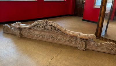 un grand miroir au milieu d'une pièce aux murs rouges