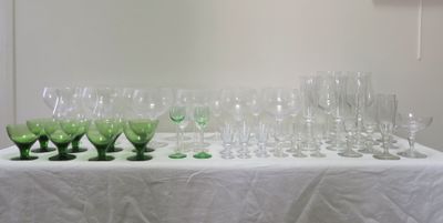 de nombreux verres à vin posés sur une table recouverte d'une nappe blanche