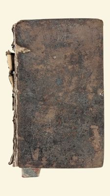 un vieux livre posé sur une table couverte de terre
