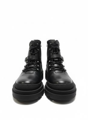 une paire de bottes en cuir noir sur fond blanc