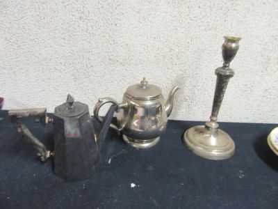 three silver teapots and two silver candlesticks on a table