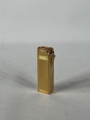 un briquet doré posé sur une surface blanche