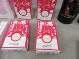 three boxes of soap sitting on top of a table next to a bottle of wine