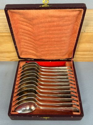 six cuillères dans un coffret en bois avec un couvercle rouge