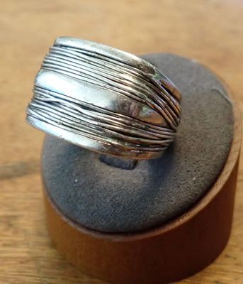sterling silver ring on a wooden stand on a wooden surface
