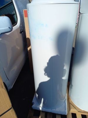 un réfrigérateur blanc posé sur une palette à côté d'une camionnette blanche