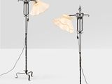 a pair of floor lamps with lampshads on each of them