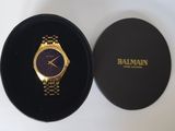 une image représentant une montre en or dans un écrin noir posé sur une surface blanche