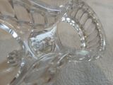 un saladier en verre transparent muni d'une poignée, posé sur une table