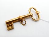 a gold key that is attached to a white string