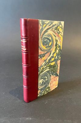 a red book sitting on top of a table next to a gray wall