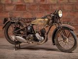 a old motorcycle that is parked in front of a brick wall