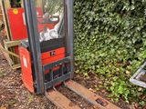a forklift that is sitting on the ground in front of a fence