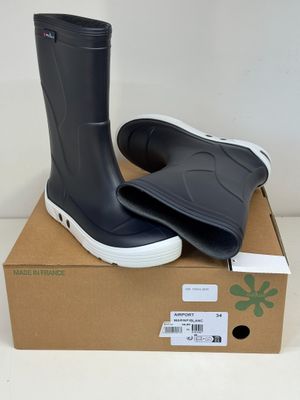 une paire de bottes de pluie noires posée sur une boîte en carton
