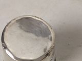 a small silver container sitting on a white surface