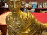 a gold statue of a man holding a dog