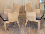 two wooden chairs that are sitting on a wooden floor