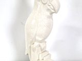 a white sculpture of a bird sitting on top of a box