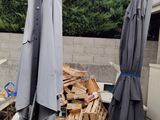 two umbrellas that are next to a pile of wood